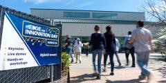 people pass by an outdoor banner advertising the event